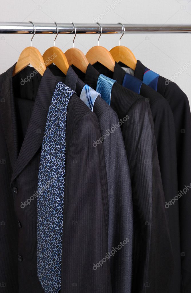 Suits and ties on hangers on gray background Stock Photo by ©belchonock 29626921