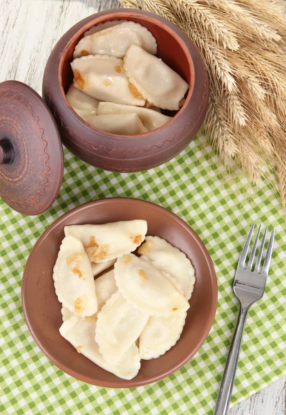 Bolinhos saborosos com cebola frita na placa marrom, no fundo de madeira — Fotografia de Stock