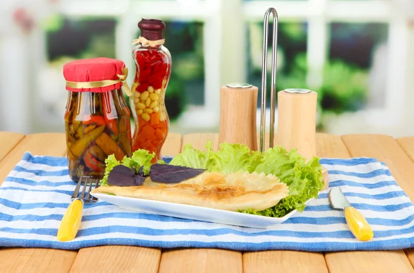 Leckere Chebureks mit frischen Kräutern auf Teller, Holztisch, auf hellem Hintergrund — Stockfoto