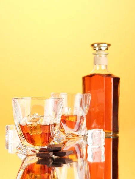 Garrafa e dois copos de uísque escocês, em fundo de cor — Fotografia de Stock