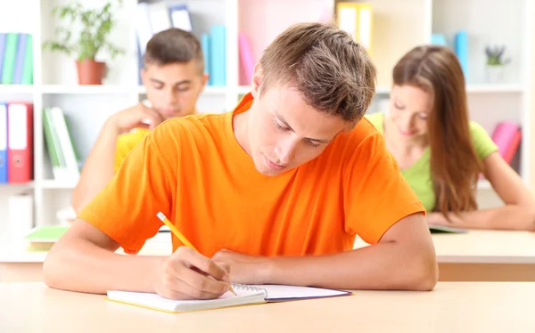 Skupina mladých studentů, sedět v knihovně — Stock fotografie