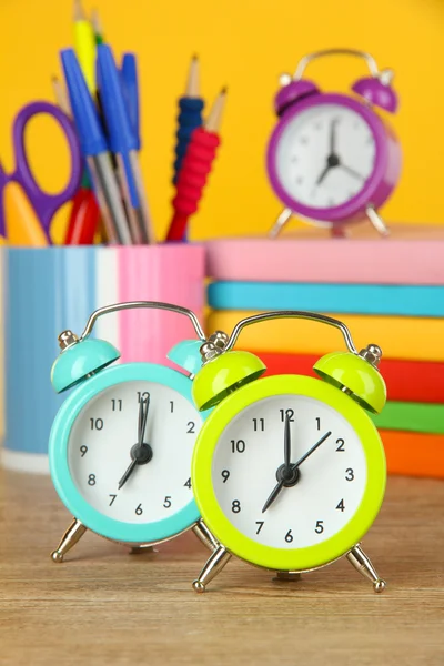 Colorful alarm clock on table on yellow background — Stock Photo, Image
