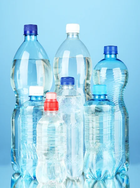 Bottles of water, on blue background — Stock fotografie