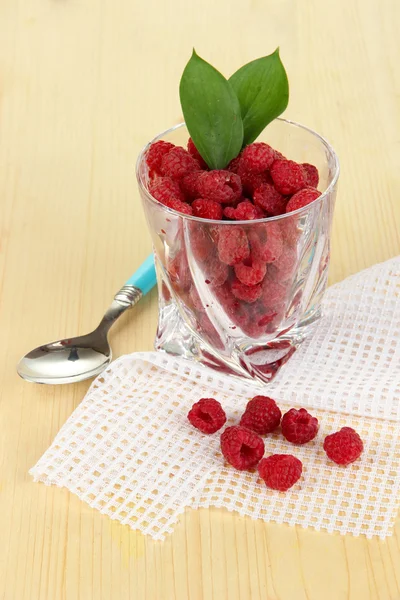 Reife Himbeeren im Glas auf Holztisch in Großaufnahme — Stockfoto