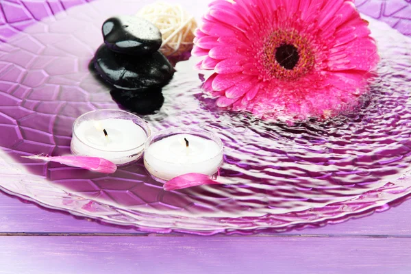 Spa stones, beautiful gerbera and candles on water — Stock Photo, Image