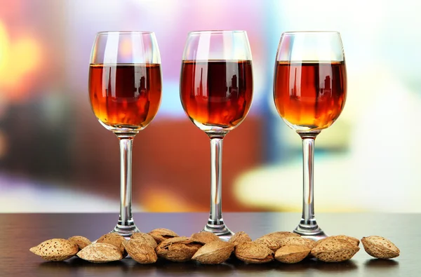 Glasses of amaretto liquor and roasted almonds, on bright background — Stock Photo, Image