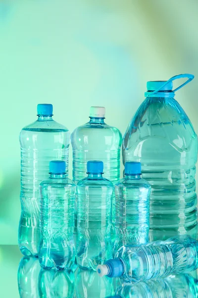 Agua en diferentes botellas sobre fondo claro —  Fotos de Stock