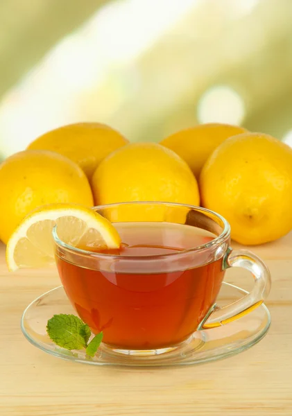 Cup of tea with lemon on table on light background — Stock Photo, Image