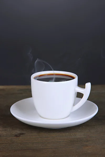 Cup of coffee on wooden table on black background — Stock Photo, Image