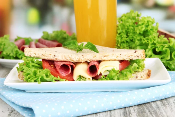 Sammensetning med fruktjuice og velsmakende smørbrød med salamipølse og grønnsaker på fargepapir, på trebordsbakgrunn – stockfoto