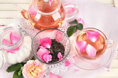 Kettle ve çay gülü peçete ahşap zemin üzerinde gelen