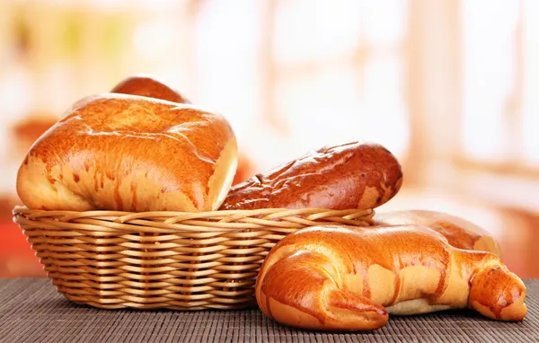 Brot gebacken in Weidenkorb auf Fensterhintergrund — Stockfoto