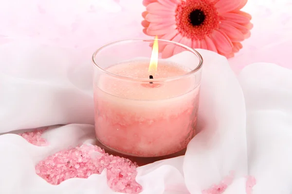 Beautiful candle with flower on white cloth, close up — Stock Photo, Image