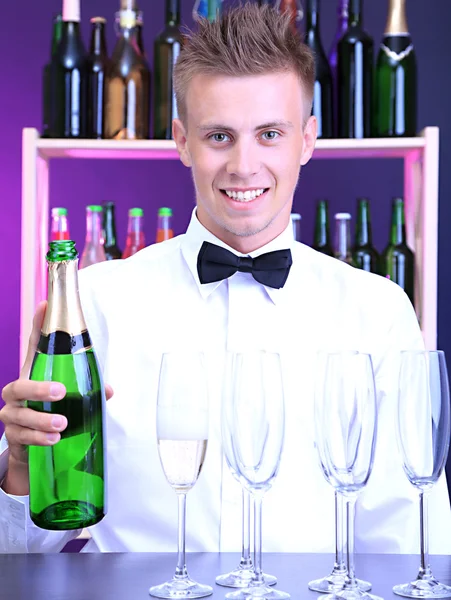 Bartender is pouring champagne into glasses — Stock Photo, Image