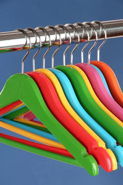 mavi arka plan üzerinde renkli elbise askıları