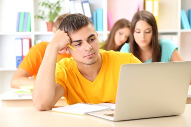 Kütüphanede oturan genç öğrenci grubu