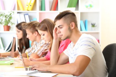 Kütüphanede oturan genç öğrenci grubu