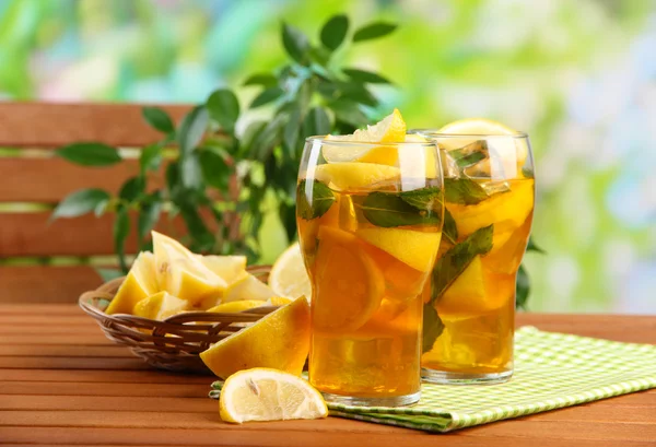 Iced tea with lemon and mint on wooden table, outdoors — Stock Photo, Image