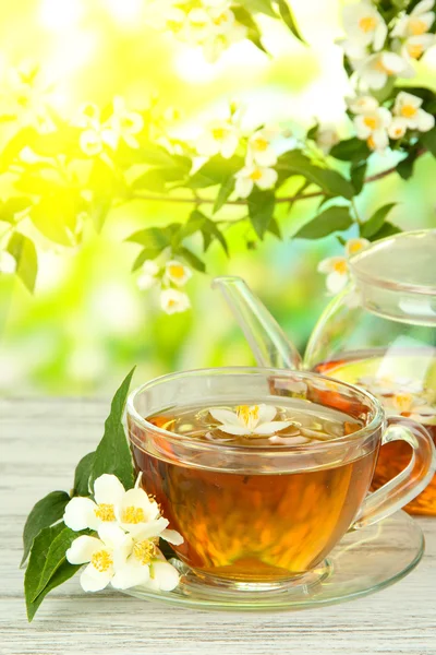 Cup of tea with jasmine, on wooden table, on bright background — Stock Photo, Image