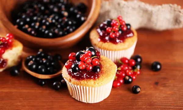 Вкусные кексы с ягодами на деревянном столе — стоковое фото