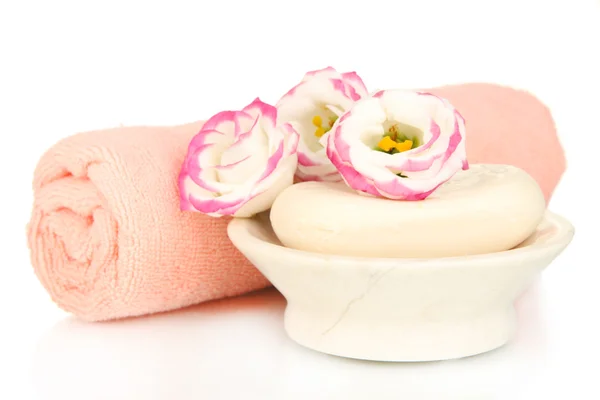 Hengerelt rózsaszín törölköző, szappan és gyönyörű virág elszigetelt fehér — Stock Fotó