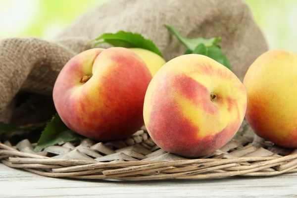 Reife süße Pfirsiche auf Holztisch im Garten, Nahaufnahme — Stockfoto