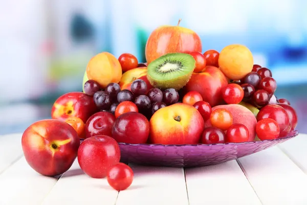Sortimento de frutas suculentas na mesa de madeira, no fundo brilhante — Fotografia de Stock