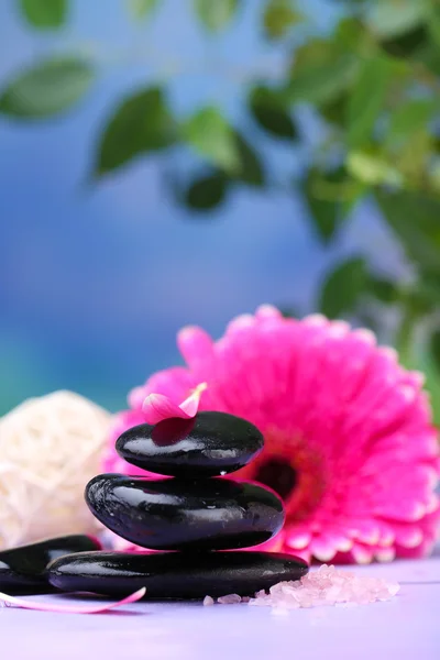 Spa stones and beautiful gerbera on wooden table — Stock Photo, Image