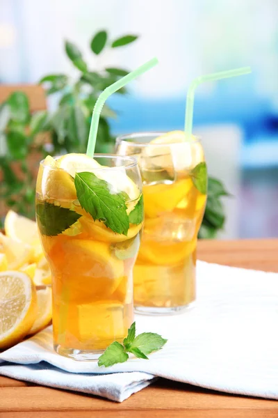 Té helado con limón y menta en la mesa de madera, al aire libre —  Fotos de Stock