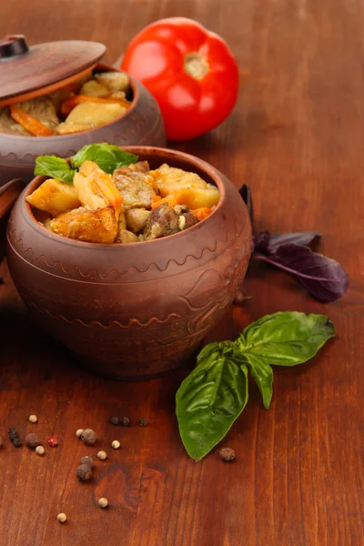 Sauté de bœuf fait maison avec des légumes dans des pots sur fond en bois — Photo