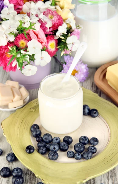 Produtos lácteos frescos com mirtilo na mesa de madeira close-up — Fotografia de Stock