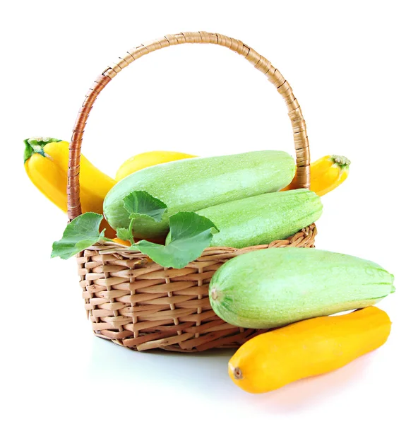 Rohe gelbe und grüne Zucchini im Weidenkorb, isoliert auf weiß — Stockfoto
