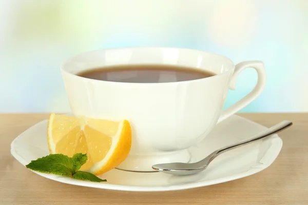 Cup of tea with lemon on table on light background — Stock Photo, Image