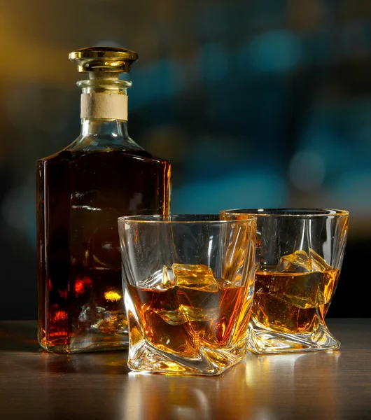 Glass of whiskey with bottle, on dark background — Stock Photo, Image