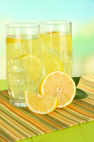 Délicieuse limonade sur table sur fond bleu clair — Photo