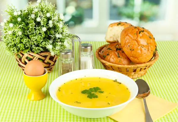 Fragrant soup in white plate on green tablecloth on window background close-up — Stock Photo, Image