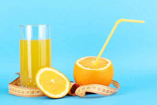 Спелые апельсины и сок как символ диеты на синем фоне — стоковое фото