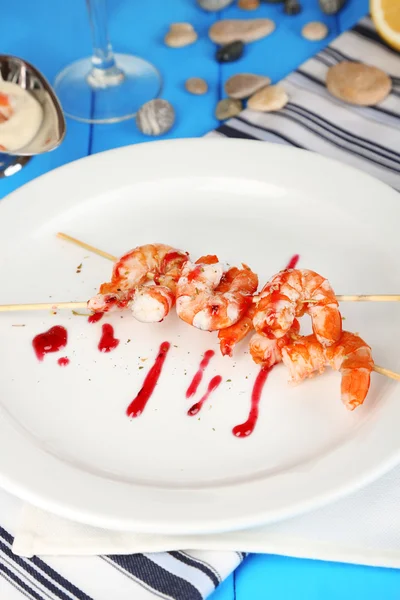Grilled shrimp with sauce on plate on wooden table close-up — Stock Photo, Image