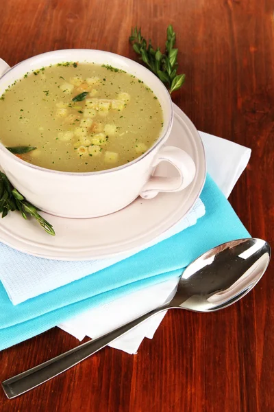 Nourishing soup in pink pan on wooden table close-up — Stock Photo, Image