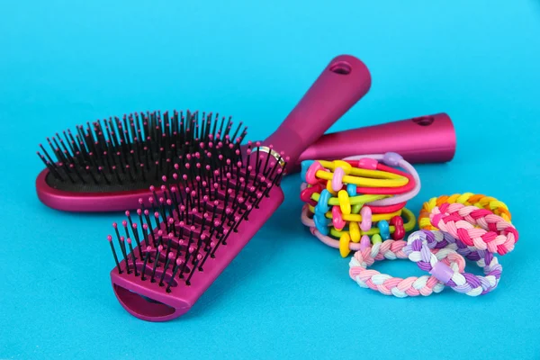 Scrunchies, escova de cabelo e cabelo - clipe em um fundo azul — Fotografia de Stock