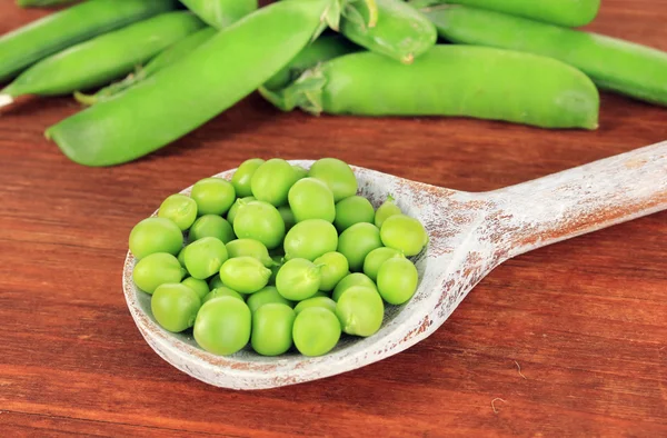 Guisantes verdes dulces sobre fondo de madera — Foto de Stock