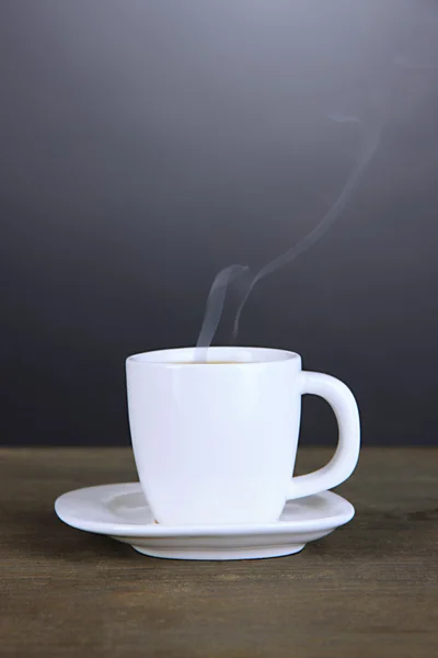 Cup of coffee on wooden table on black background — Stock Photo, Image