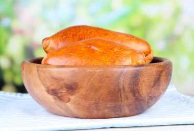 parlak zemin üzerine ahşap masa üzerinde ahşap kase taze pişmiş pasties