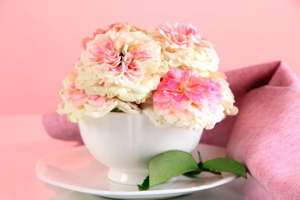 Rozen in cup op servetten op roze achtergrond — Stockfoto