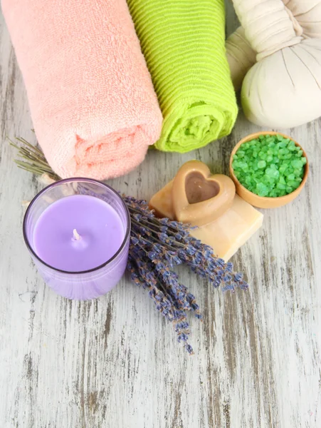 Natureza morta com vela de lavanda, sabão, bolas de massagem, sabão e lavanda fresca, sobre fundo de madeira — Fotografia de Stock