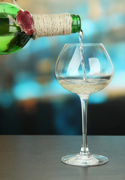 Vino bianco versato in bicchiere di vino, su sfondo luminoso — Foto Stock