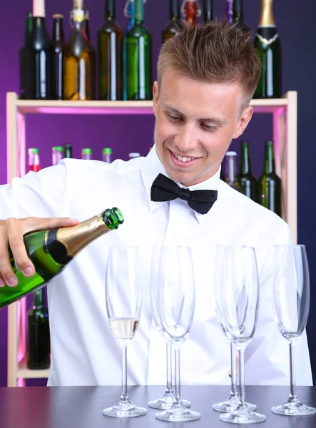 Barman está derramando champanhe em copos — Fotografia de Stock