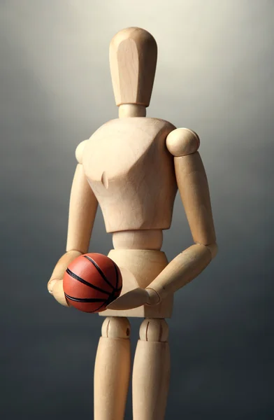 Mannequin en bois avec ballon de basket sur fond gris — Photo