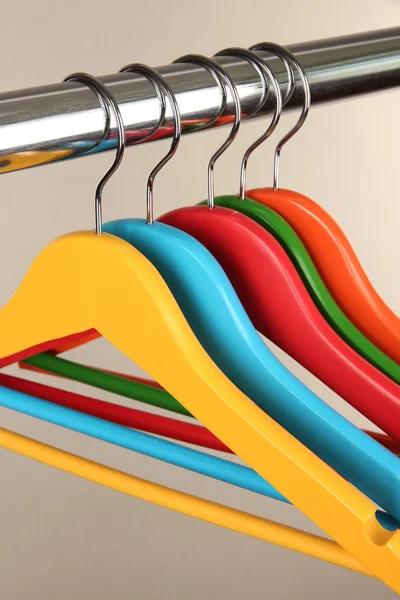 Kleurrijke kleerhangers op grijze achtergrond — Stockfoto