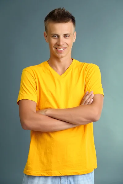 T-Shirt auf jungem Mann, auf grauem Hintergrund — Stockfoto